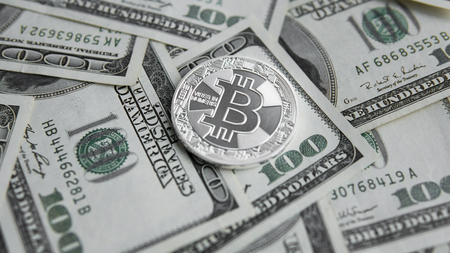Silver Bitcoins on US dollars. Digital currency close-up. Virtual money. Crypto currency. Metal coins of bitcoins on banknotes of one hundred dollars. Exchange. Bussiness, commercial.の写真素材