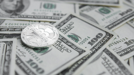 Silver Bitcoins on US dollars. Digital currency close-up. Virtual money. Crypto currency. Metal coins of bitcoins on banknotes of one hundred dollars. Exchange. Bussiness, commercial.の写真素材