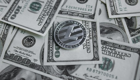 Litecoins crypto currebcy on US dollars. Digital currency close-up. Virtual money. Metal coins of Litecoins on banknotes of one hundred dollars. Exchange. Bussiness, commercial.の写真素材