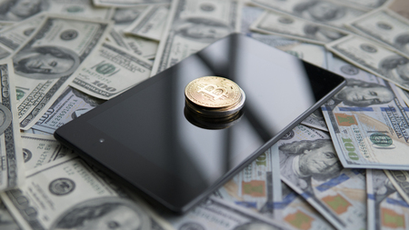 Bitcoins on a us dollars and on the tablet. Bitcoin crypto currebcy on US dollars. Digital currency. Virtual money. Metal coins of bitcoin on banknotes. Bussiness, commercial.の写真素材