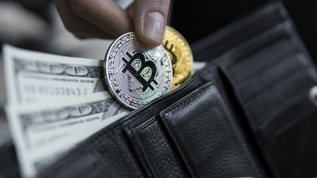 Golden and silver bitcoins and hundred dollar bills in leather wallet. Bitcoin with dollar in purse. Profit from mining crypto currencies. Miner with dollars and gold bitcoin. Bussiness, commercial.の写真素材