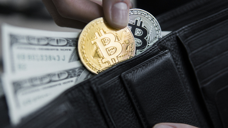 Golden and silver bitcoins and hundred dollar bills in leather wallet. Bitcoin with dollar in purse. Profit from mining crypto currencies. Miner with dollars and gold bitcoin. Bussiness, commercial.の写真素材