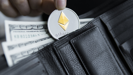 Ethereum coin and hundred dollars bills in leather wallet. Ethereum with dollar in purse. Profit from mining crypto currencies. Miner with dollars and gold Ethereum money. Bussiness, commercial.の写真素材