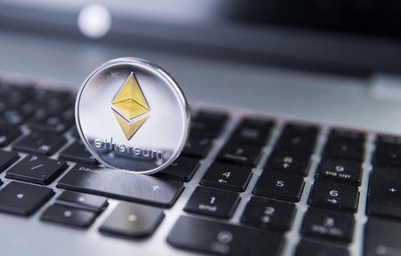 Ethereum coin on a laptop. Ethereum crypto currency on a laptop black keyboard. Digital currency. Virtual money. Metal coins of Ethereum. Bussiness, commercial, Exchange.の写真素材