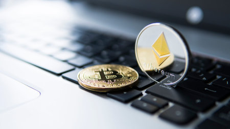 Golden bitcoin and Ethereum coins on a laptop. Crypto currency on a computer black keyboard. Digital...
