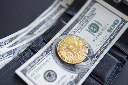 Close up golden coin bitcoin on us hundred dollars on leather a wallet with full of money. Profit from mining crypto currencies. Miner with dollars and gold bitcoin. Bussiness, commercial. Currency.の写真素材
