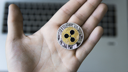 Ripple coin on a laptop keyboard closeup on a miner hand. Blockchain mining. Digital money and virtual cryptocurrency concept. Crypto currency investment. Digital money. Bussiness, commercial.の写真素材