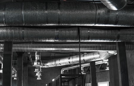 Ventilation system on the ceiling of large buildings. Ventilation pipes in silver insulation material hanging from the ceiling inside new building.の写真素材