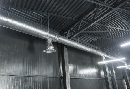 Ventilation system on the ceiling of large buildings. Ventilation pipes in silver insulation material hanging from the ceiling inside new building.の写真素材