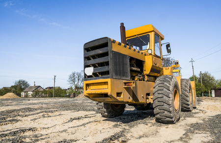 Yellow loader stands on a stone gravel during road construction works. The stones for the road. Unloading stone.の写真素材
