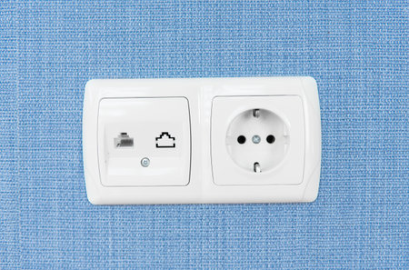 Socket on a blue wall, a multifunction outlet with an internet connection and european-style outlets