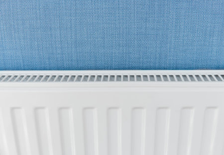 White radiator in an apartment with a blue walls.