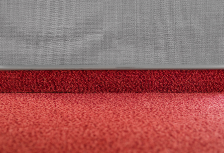 Carpet floor with a carpet baseboard on a grey wall.の写真素材