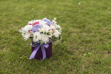 Close-up of bridal white violet rose bouquet on background of green grass.の写真素材
