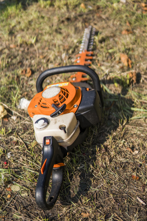Orange gasoline engine portable chainsaw on a grass.の写真素材