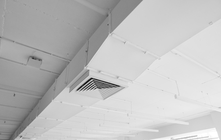Ventilation system on the ceiling of large buildings. Ventilation pipes in silver insulation material hanging from the ceiling inside new building.の写真素材