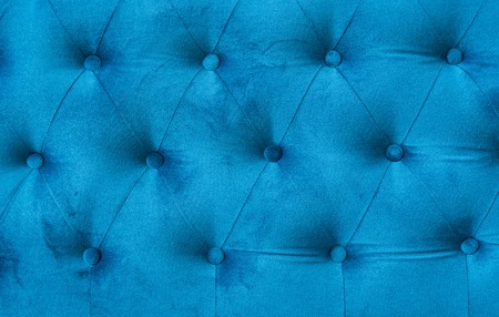 Velour surface of sofa close-up. Coach-type velours screed tightened with buttons. Blue chesterfield style quilted upholstery backdrop close up.の写真素材