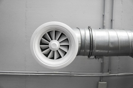 Ventilation system on the ceiling of large buildings. Ventilation pipes in silver insulation material hanging from the ceiling inside new building.の写真素材
