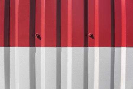 Metal white and red sheet for industrial building and construction. Roof sheet metal or corrugated roofs of factory building or warehouse.の写真素材