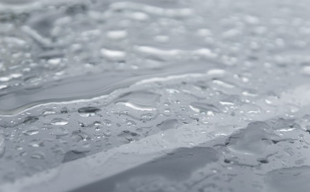 Natural water drops on a glass table after rain.の写真素材