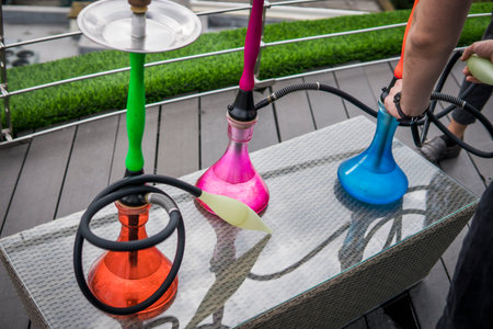 Three colors hookahs on table in hookah lounge in a day.