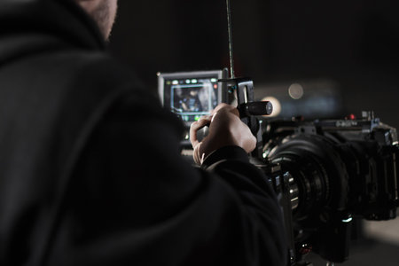 Professional videographer holding camera mounted on easy rig. Videographer using steadicam. Pro...