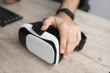 VR virtual reality glasses on a table with a man hand.