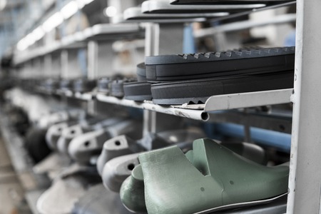 The conveyor on a shoes factory with shoe and sole. Mass production of footwear.の写真素材