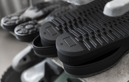 The conveyor on a shoes factory with shoe and sole. Mass production of footwear.の写真素材