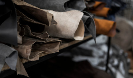 Different pieces of leather in a rolls. The pieces of the colored leathers. Rolls of natural brown...