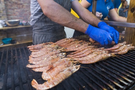 Cooking fresh kings shrimp on a grill on a foodfest.の写真素材