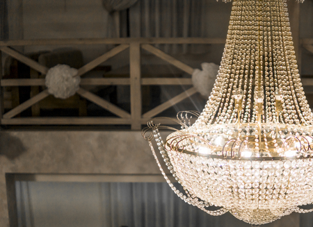 A shiny big beautiful chandelier in a big room hall.の写真素材