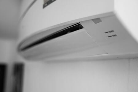 Air conditioner mounted on a white wall in the living room or bedroom. Indooor comfort temperature. Health concepts and energy savings.の写真素材