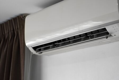 Air conditioner mounted on a white wall in the living room or bedroom. Indooor comfort temperature. Health concepts and energy savings.の写真素材