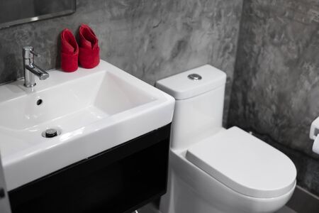 Modern stainless steel faucet with wash basin sink with a two red towels on it . Counter bathroom interior contemporary. Luxury and stylish design bathroom with a concrete style walls.の写真素材