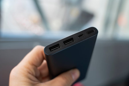 Man is holding the power bank a an the charger. Powerbank in hand. Power-saving device for...