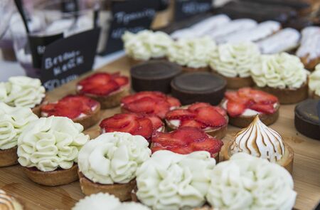 Background filled with colorful cakes and desserts with fresh fruits. Assorted different mini cakes with cream, chocolate and berriesの写真素材