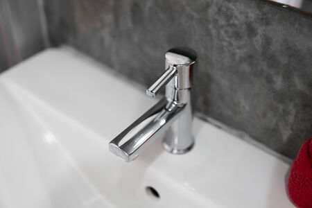 Modern stainless steel faucet with wash basin sink. Counter bathroom interior contemporary. Luxury and stylish design bathroom with a concrete style walls.の写真素材