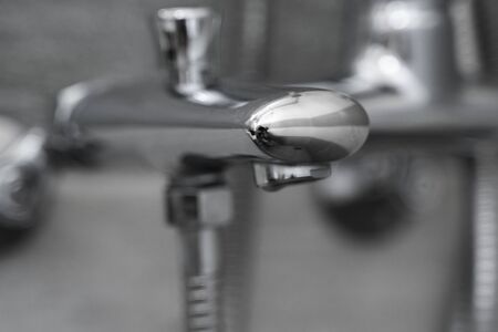 Modern designer tap and shower in bathroom. Closeup of chrome shower, faucet, in the bathroom covered decorative ceramic. Mixer cold hot water.の写真素材