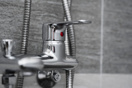 Modern designer tap and shower in bathroom. Closeup of chrome shower, faucet, in the bathroom...