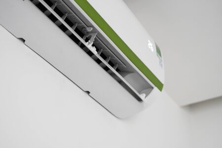 Air conditioner mounted on a white wall in the living room or bedroom. Indooor comfort temperature. Health concepts and energy savings.の写真素材
