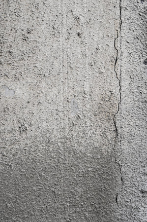 Cracked concrete grey wall covered with gray cement texture as background can be used in design....