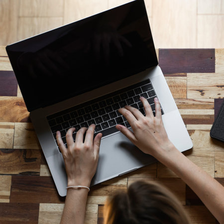 Womans hands typing on laptop keyboard top view. Study and work online, freelance. Self employed or...