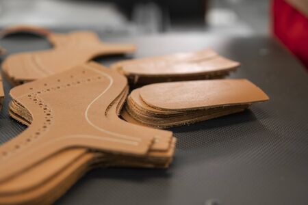 Different forms of leather pieces which will be use for making a shoes on a shoes factory. Prepared, bundled leather parts, used in the production of shoes.の写真素材