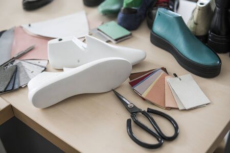 Shoemaker workplace with tools, shoes, leather and last.の写真素材