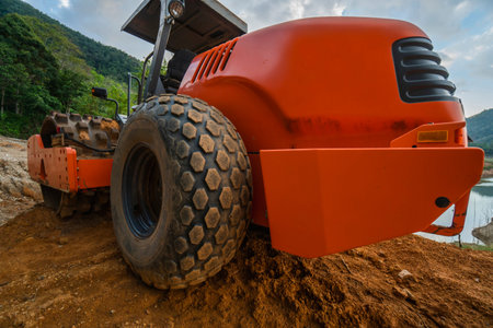 Soil compactor with vibratory padfoot drum. Heavy duty machinery working on highway construction...