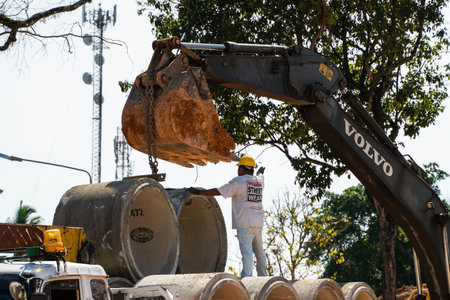 THAILAND, PHUKET - December 12, 2018: Using an excavator to translate large pipes into a vehicle...