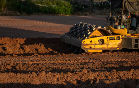 Soil compactor with vibratory padfoot drum. Heavy duty machinery working on highway construction...