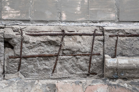 Cracked concrete grey wall with armature. Dirty concrete texture with cracks and holes