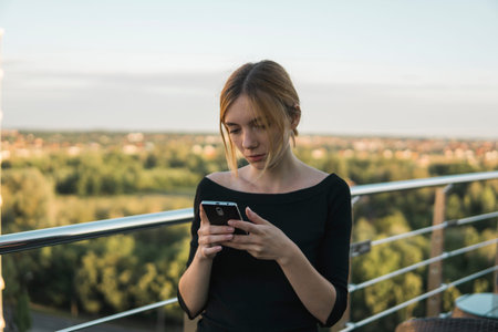 Young business woman uses phone. Good looking brunette female uses online banking on smart phone to...